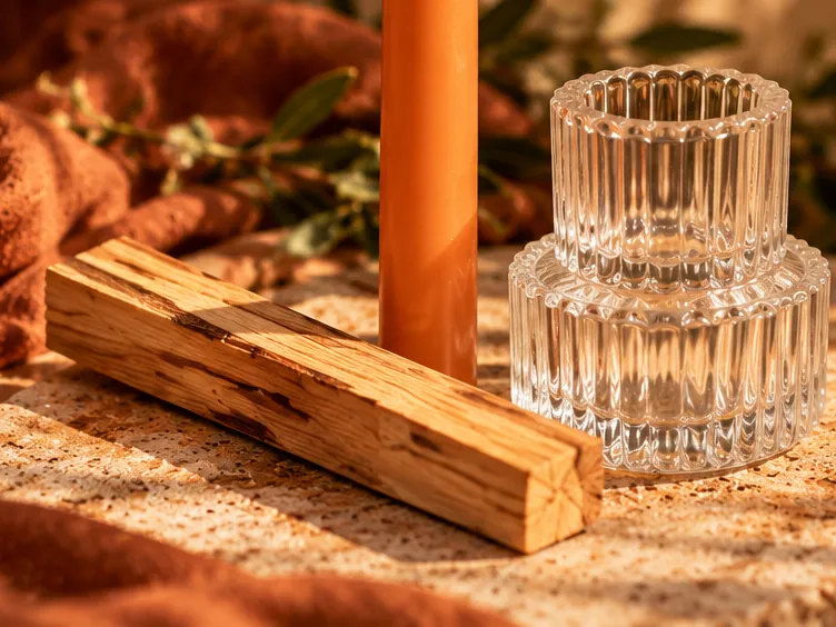 Detail of the palo santo stick and the ribbed glass taper candle holder